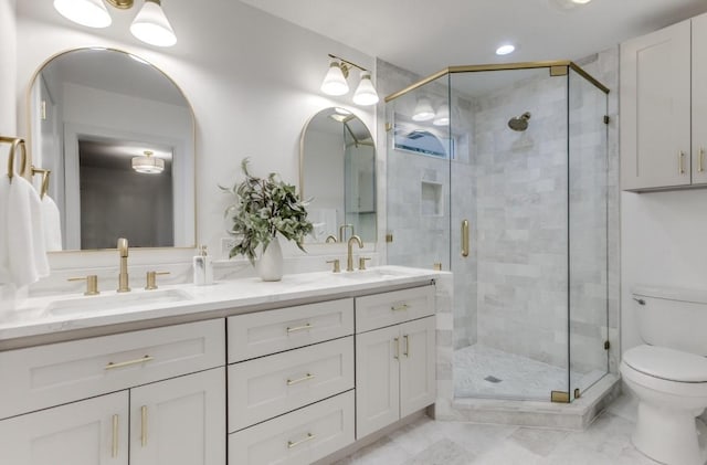 full bath with toilet, a stall shower, double vanity, and a sink