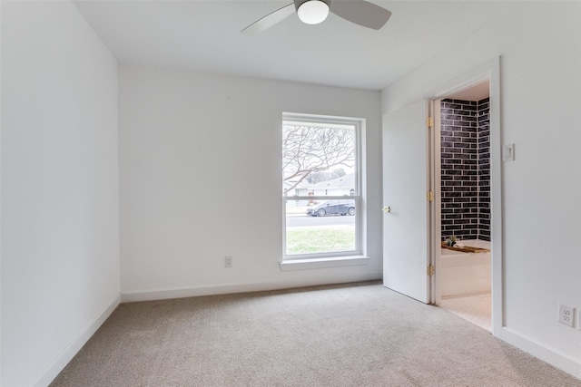 unfurnished room featuring baseboards, a ceiling fan, and light colored carpet