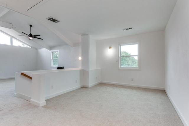 empty room with a healthy amount of sunlight, visible vents, and carpet flooring