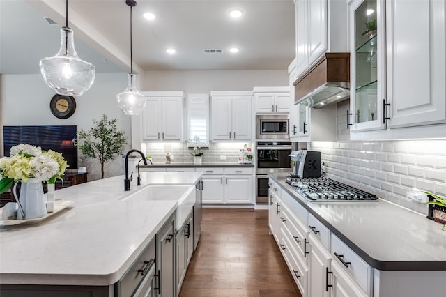 kitchen featuring a sink, visible vents, white cabinetry, appliances with stainless steel finishes, and glass insert cabinets