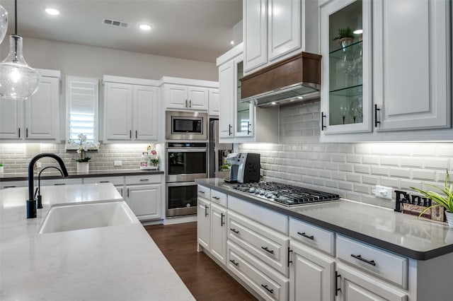 kitchen featuring visible vents, white cabinets, dark wood finished floors, stainless steel appliances, and a sink