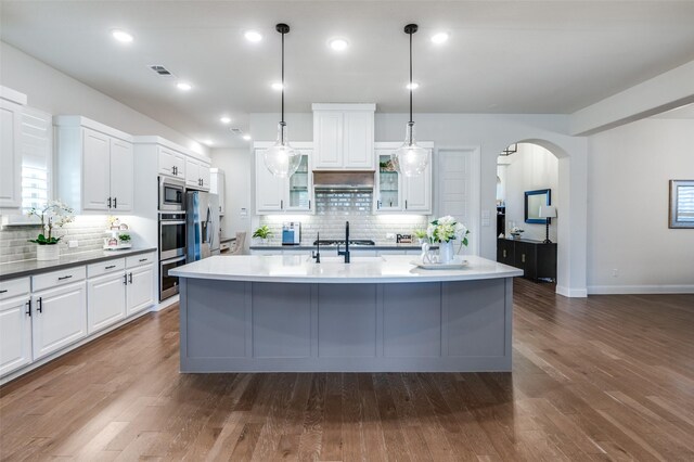 kitchen with white cabinetry, visible vents, appliances with stainless steel finishes, and arched walkways