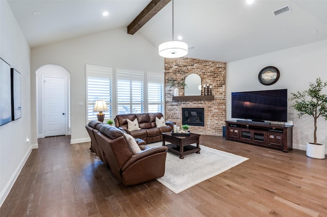 living room featuring baseboards, visible vents, wood finished floors, high vaulted ceiling, and beam ceiling