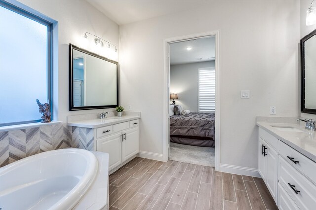 full bath with a stall shower, vanity, a garden tub, and wood finish floors