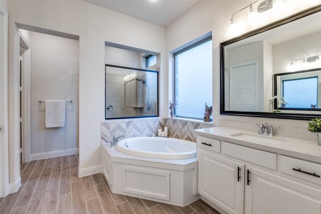 full bath featuring wood finish floors, a garden tub, visible vents, vanity, and walk in shower