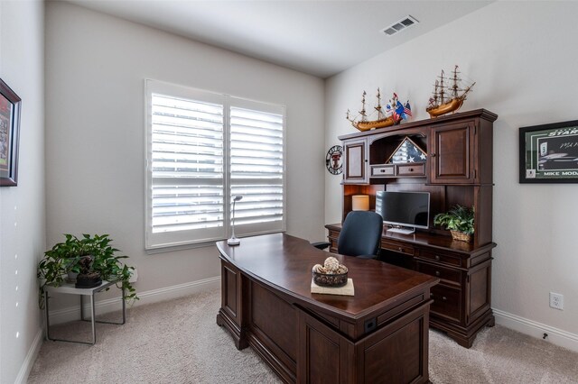 home office with baseboards, visible vents, and light colored carpet