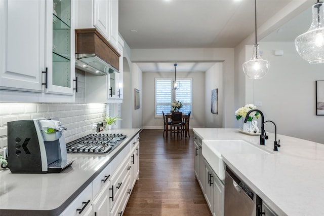 kitchen featuring dark wood-style flooring, pendant lighting, decorative backsplash, appliances with stainless steel finishes, and white cabinetry