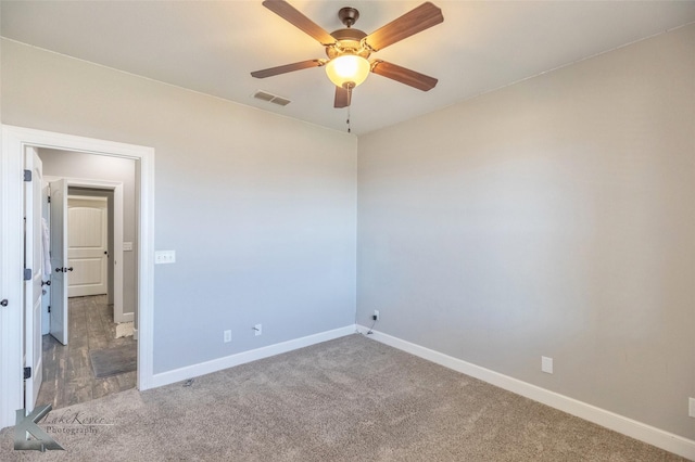 unfurnished room with carpet floors, visible vents, baseboards, and a ceiling fan