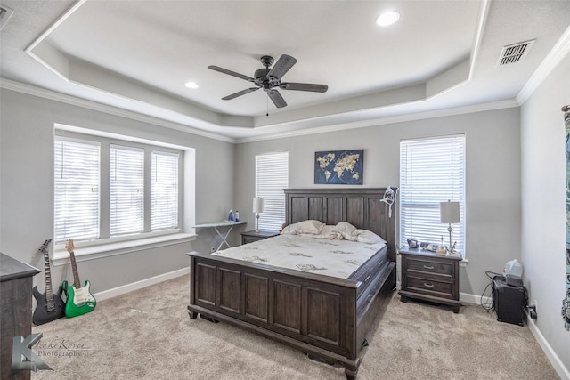 bedroom with light carpet, visible vents, and a raised ceiling