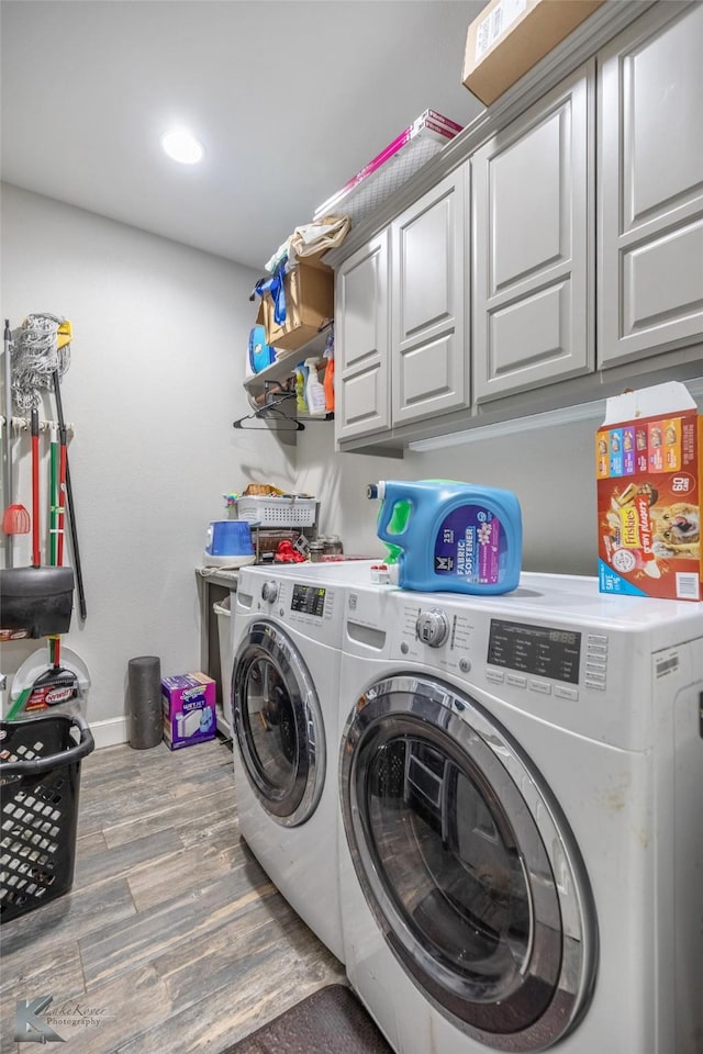 laundry room with cabinet space, baseboards, washer and dryer, and wood finished floors