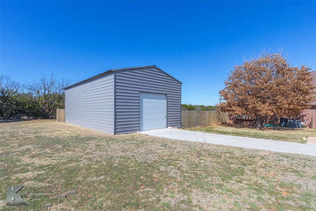 detached garage with fence and concrete driveway