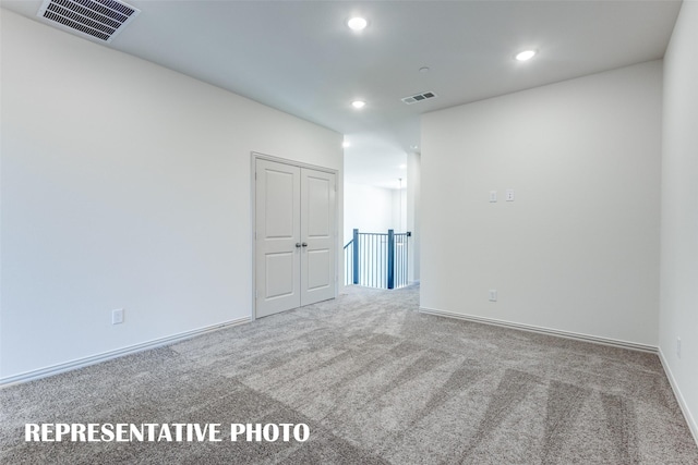 carpeted spare room with recessed lighting, visible vents, and baseboards