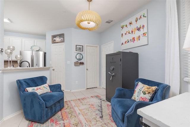 living area featuring baseboards, visible vents, and light tile patterned flooring