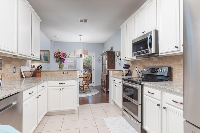 kitchen with light tile patterned floors, appliances with stainless steel finishes, and white cabinets