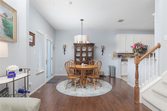 dining space featuring baseboards, stairs, visible vents, and dark wood-style flooring