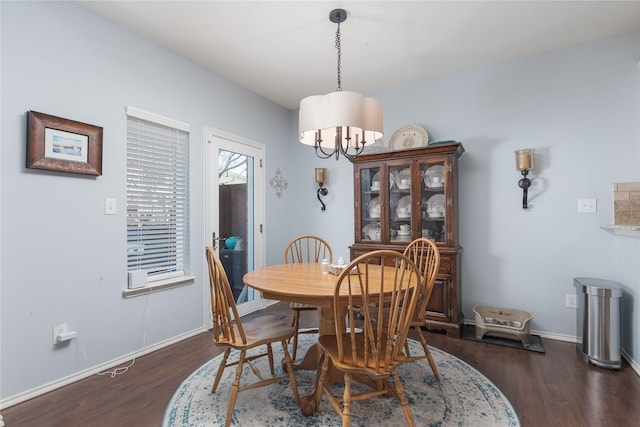 dining area with baseboards, dark wood-style flooring, and a notable chandelier