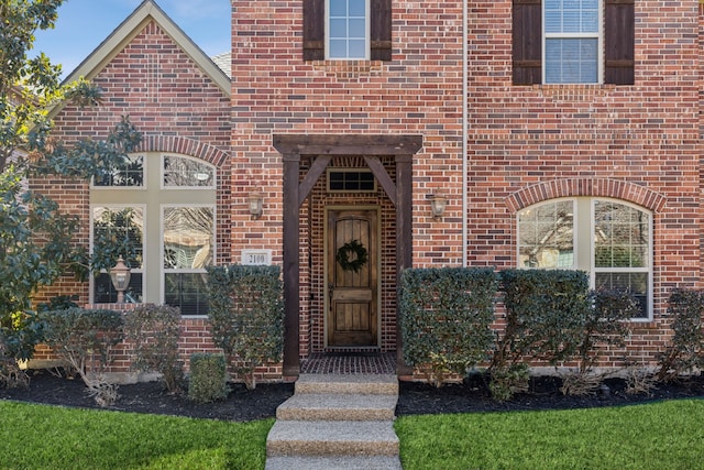 entrance to property featuring brick siding