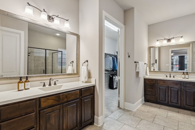 full bathroom featuring a wealth of natural light, a shower stall, tile patterned flooring, and vanity