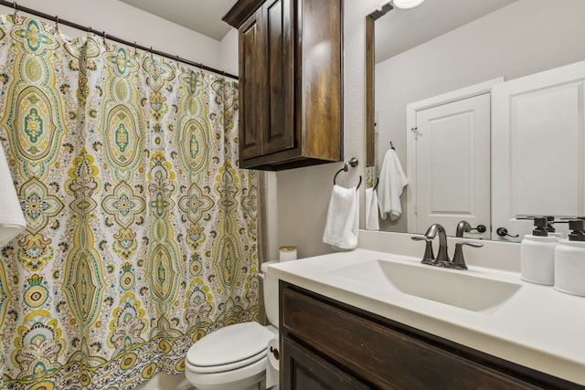 bathroom with toilet, shower / bath combo with shower curtain, and vanity