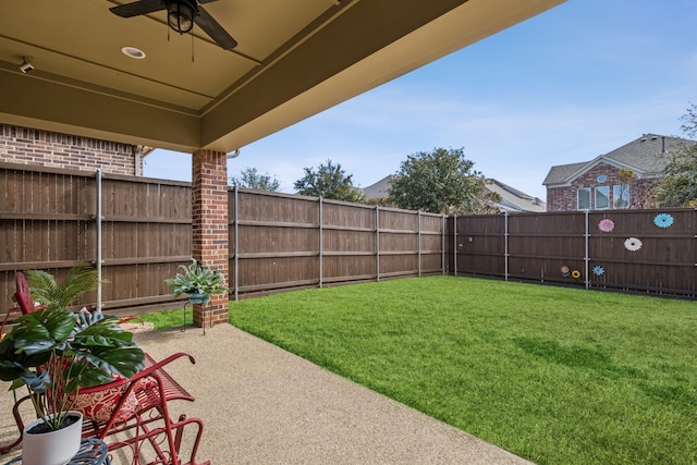 view of yard featuring ceiling fan and a fenced backyard