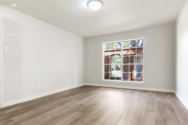 unfurnished room featuring light wood finished floors and baseboards