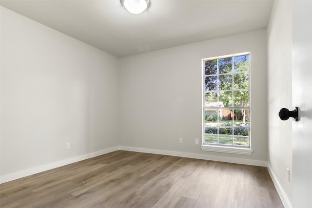 spare room with light wood-style flooring and baseboards