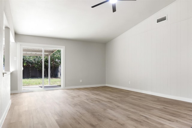 empty room with ceiling fan, lofted ceiling, visible vents, baseboards, and light wood-type flooring