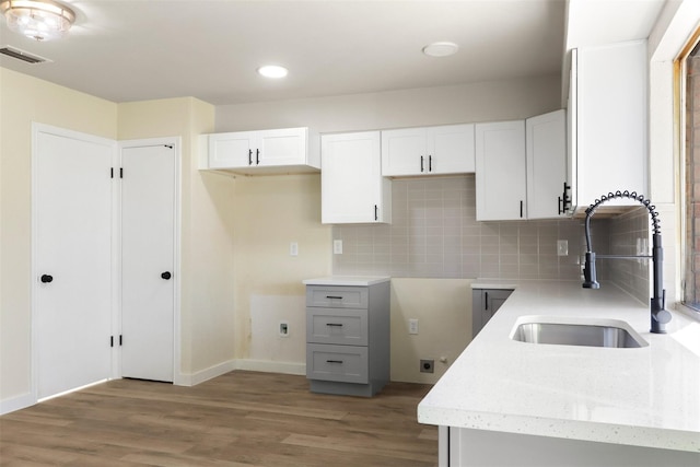 kitchen featuring a sink, visible vents, and white cabinets