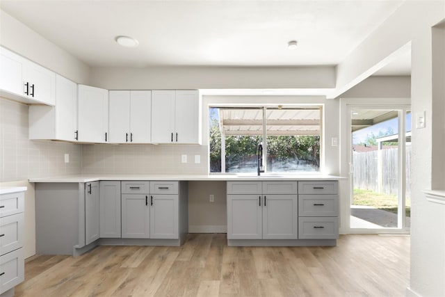 kitchen with light countertops, a sink, and gray cabinetry