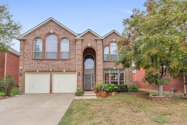 traditional home with a garage, driveway, brick siding, and a front lawn