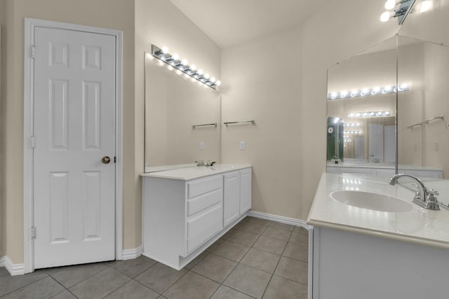 full bathroom featuring tile patterned flooring, baseboards, two vanities, and a sink