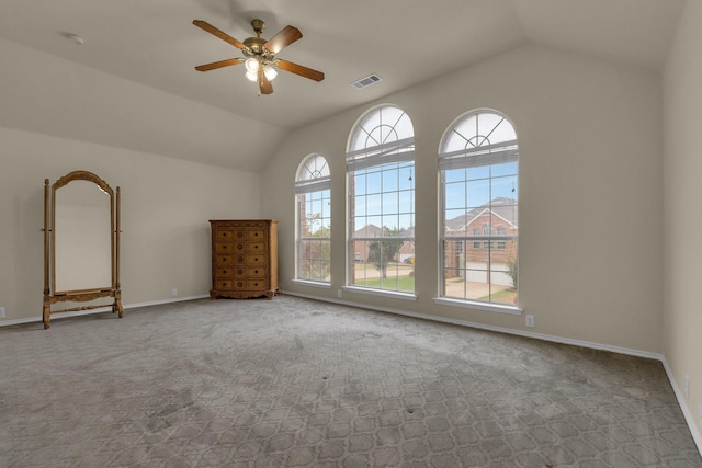 spare room featuring vaulted ceiling, a ceiling fan, visible vents, and baseboards