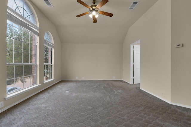 unfurnished room with dark colored carpet, visible vents, and vaulted ceiling