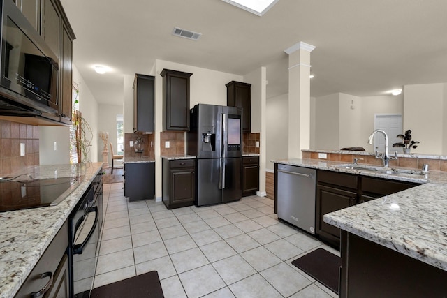 kitchen with light stone counters, stainless steel appliances, visible vents, light tile patterned flooring, and a sink