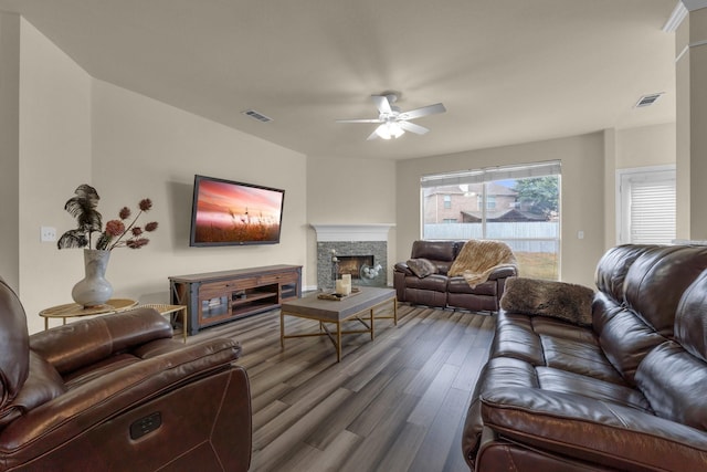 living room with ceiling fan, a fireplace, wood finished floors, and visible vents