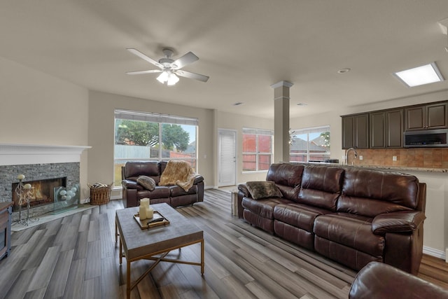 living room with wood finished floors, a wealth of natural light, and ornate columns