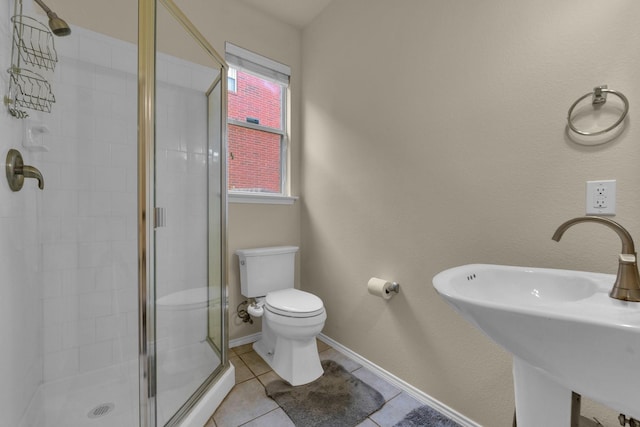 full bathroom with toilet, a sink, baseboards, a shower stall, and tile patterned floors