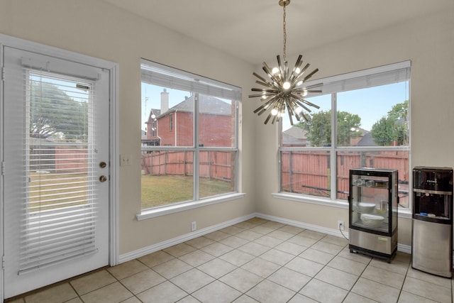 unfurnished dining area with light tile patterned floors, plenty of natural light, baseboards, and a notable chandelier