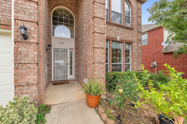 doorway to property featuring brick siding