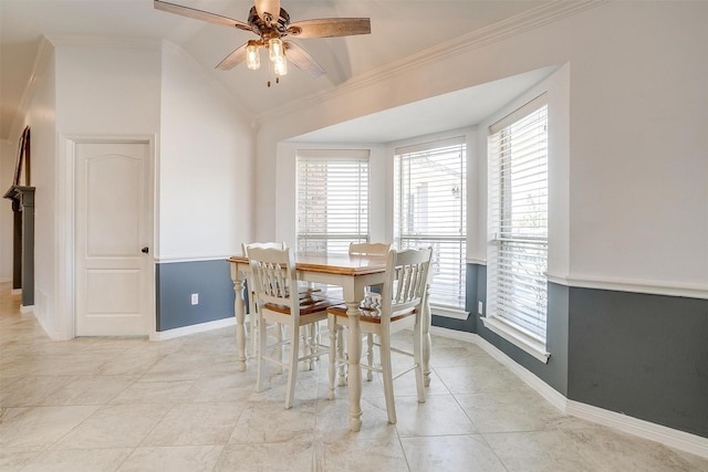 dining area featuring ceiling fan, light tile patterned floors, lofted ceiling, baseboards, and crown molding