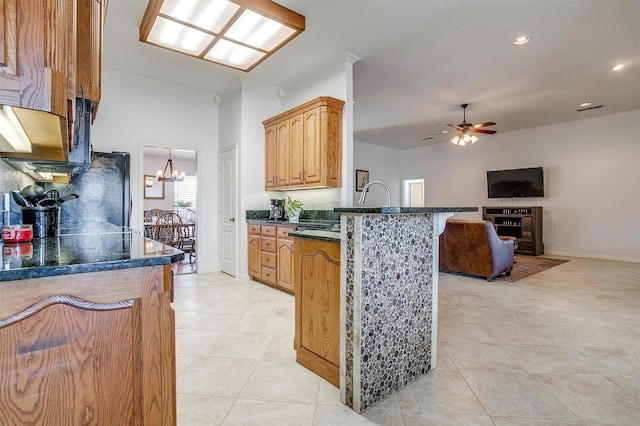 kitchen with dark countertops, ornamental molding, open floor plan, freestanding refrigerator, and a peninsula