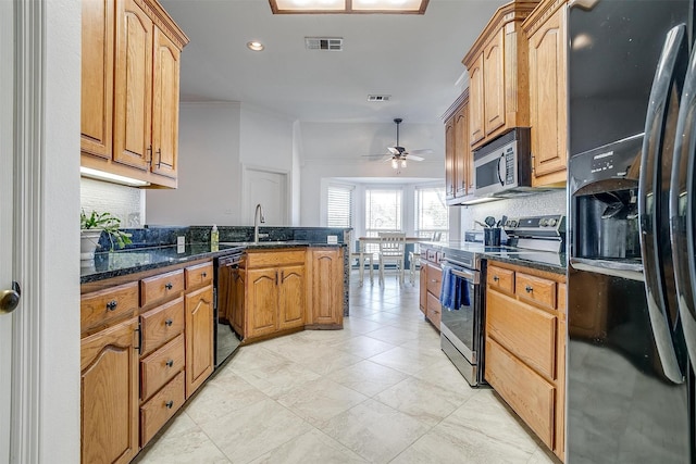 kitchen with black appliances, tasteful backsplash, a sink, and visible vents