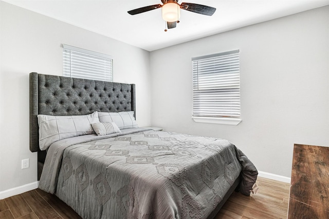 bedroom with ceiling fan, baseboards, and wood finished floors