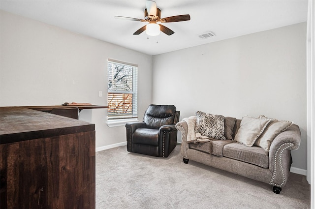 carpeted living area with visible vents, baseboards, and a ceiling fan