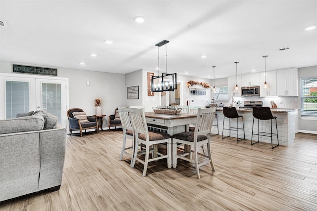 dining room featuring recessed lighting, visible vents, a healthy amount of sunlight, and light wood finished floors