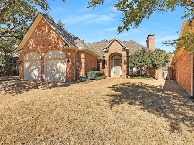 view of front of house featuring an attached garage, brick siding, concrete driveway, roof with shingles, and a chimney