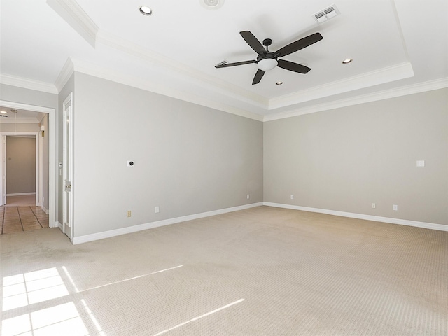 empty room featuring light carpet, a tray ceiling, and visible vents