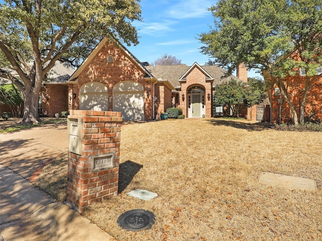 view of front of property with brick siding, a front lawn, and an attached garage