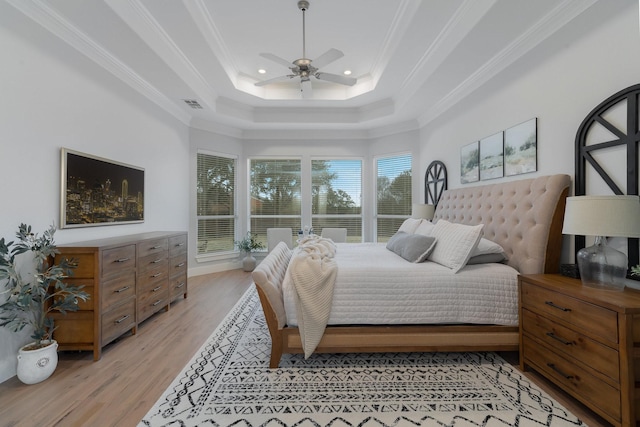 bedroom with recessed lighting, visible vents, light wood-type flooring, a tray ceiling, and crown molding