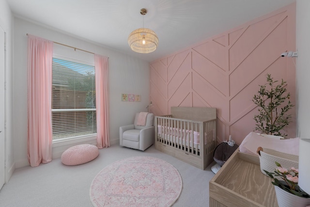 bedroom featuring a crib and light colored carpet